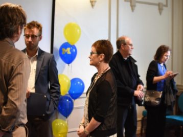 Dr. Brenda Gunderson talking with students and family after the 2017 graduation reception 